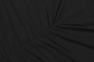 Macro view of the elegant ruching and pleated fabric detail on the black dress