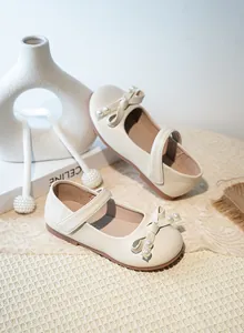 Vue rapprochée du détail du nœud en perles sur ces chaussures de princesse pour fille