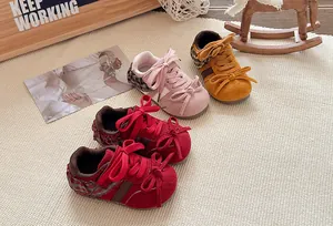 Detailweergave van gekleurde retro kindersneakers met strik en kanten accenten.
