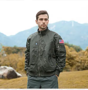 Men's olive green tactical flight jacket with American flag patch in outdoor setting