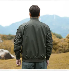 Back view of a men's olive green tactical flight bomber jacket in an outdoor setting
