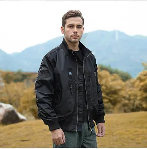 Man wearing a black tactical flight bomber jacket with stand collar in outdoor setting