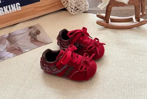 Detailopname van rode kindersneakers met schattige strikjes en kanten versieringen