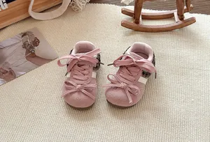 Detailweergave van roze peutersneakers voor meisjes met strikjes en kantaccenten