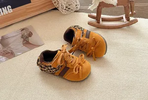 Gedetailleerd overzicht van gele kinderschoenen met strikken en geruit kantwerk mooi