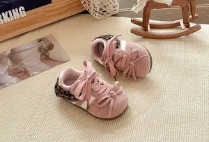 Close-up van schattige roze kindersneakers met grote strikken en fijne kantdetails