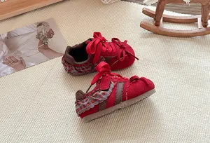 Detailweergave van rode kinderloopschoenen met geruite ruches en rode veters.