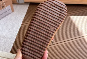 Detailopname van de antislip rubberen zool met groeven van bruine klompen voor meisjes