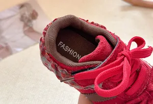 Detailopname van rode kinderschoenen met elegante strik en kanten rand voor meisjes