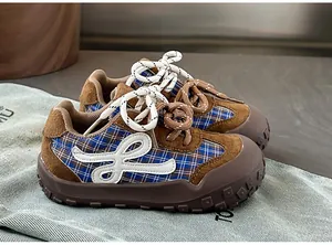 Détail de baskets rétro pour tout-petits avec daim marron et semelles en caoutchouc souples.