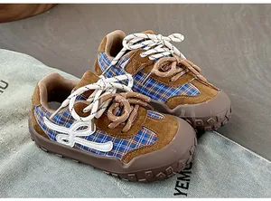 Détail de baskets style allemand pour enfants en daim marron et tissu à carreaux bleus