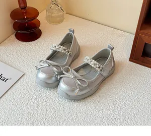 Detailed shot of silver girls princess shoes featuring pearl rhinestone strap and bow