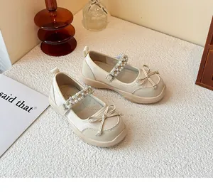 Elegant girl's cream Mary Jane shoes featuring a bowknot and a pearl rhinestone strap