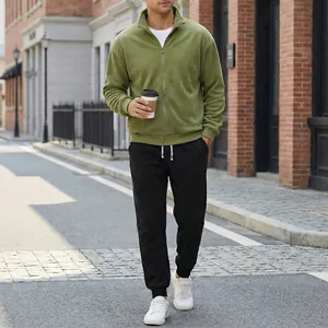 Vista dettagliata della giacca in pile verde e jogger neri in stile urban chic