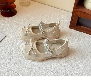 Detailed view of elegant cream children's Mary Jane shoes with pearl and bow straps