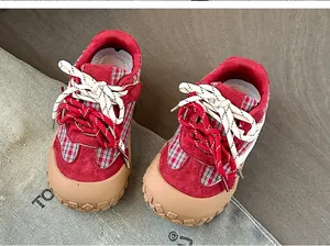 Vue détaillée des baskets pour enfants en daim rouge avec motif à carreaux et embout en caoutchouc