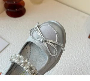 Close-up of silver girls princess shoes featuring a bow and rhinestone pearl strap detail