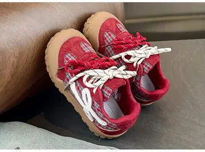 Gros plan de chaussures de sport à carreaux rouges pour enfants avec semelles souples