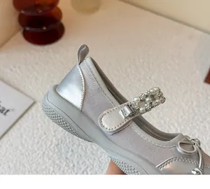 Close-up detail of a silver children's Mary Jane shoe featuring a pearl and rhinestone strap