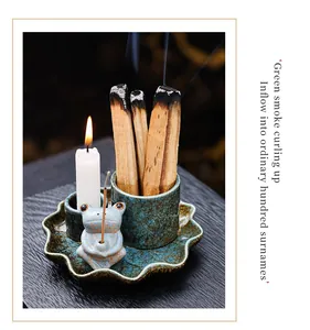 Detailed macro shot of a ceramic frog incense burner with Palo Santo sticks and candle