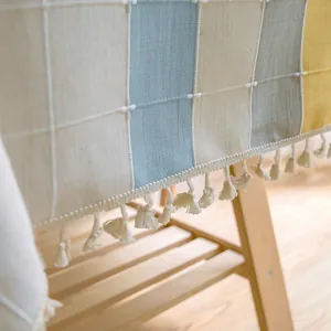 Nahaufnahme einer karierten Tischdecke in Leinenoptik mit feinen weißen Fransen