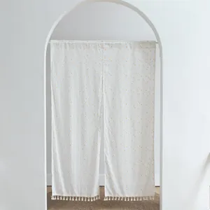 Detailed view of white polka dot door curtain fabric partition with tassels