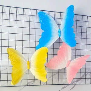 Primer plano de tres clips de mariposa de papel degradado para decoración de paredes.