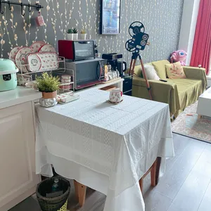 Elegant French style white lace tablecloth with delicate embroidery in a home setting