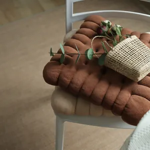 High-quality detail of two biscuit-shaped soft plush seat cushions on a white chair
