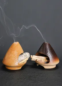 Artistic ceramic mini fireplace incense burner with smoke rising from Palo Santo wood