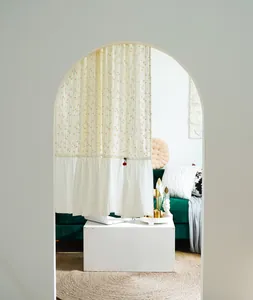 Artistic floral cotton door curtain with ruffled hem used as a partition in a home