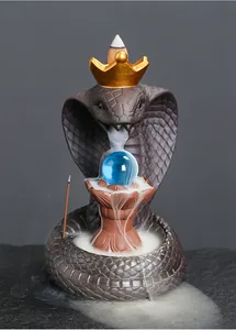 Detailed macro view of a king cobra backflow incense burner with a golden crown and blue orb.