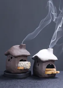 Atmospheric ceramic house incense burners with sage and palo santo sticks emitting smoke