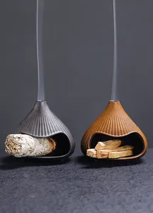 Close-up of ceramic Fuji mountain incense burners with burning white sage and wood