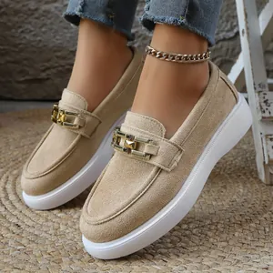 Detailaufnahme von beigefarbenen Plateau-Loafers mit eleganter goldener Metallschnalle