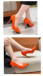 Chic orange patent leather pointed-toe stiletto heels shown in a lifestyle setting