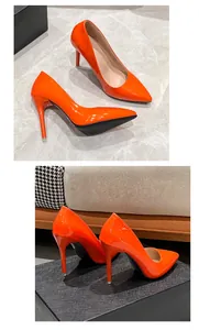 Close-up details of vibrant orange patent leather stiletto pumps with pointed toe design