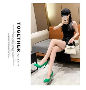 Model wearing green pointed-toe patent leather stiletto heels in a lifestyle setting