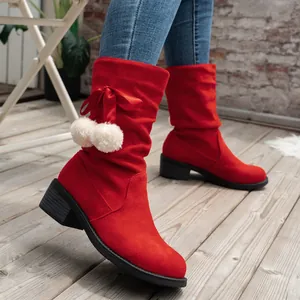 Detailed side view of red suede mid-calf boots with white pom-poms and silky bow