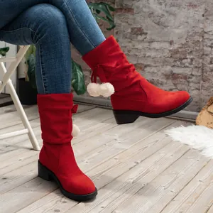 Red suede mid-calf slouch boots with white pom-pom details and chunky heels shown on model