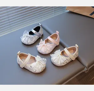 Primer plano de cuatro pares de zapatos de princesa brillantes con lazos de perlas.