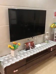 Vista detallada del camino de mesa de encaje de algodón blanco con bordado floral en 3D