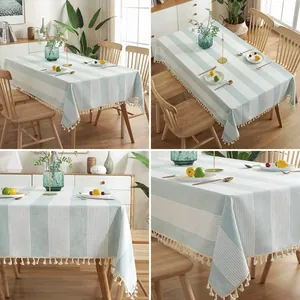 Gros plan d'une nappe en coton et lin à rayures avec des bordures à pompons.
