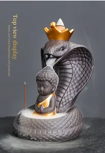 Detailed macro view of a cobra backflow incense burner featuring a Buddha and smoke effects