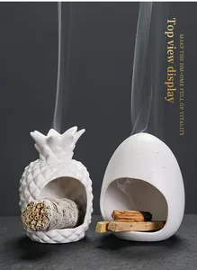 Keramische wierookhouders in ananas- en eivorm met brandende Palo Santo stokjes
