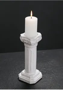 Detailed view of a lit white candle on an elegant ceramic Roman column holder