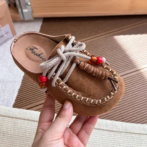Mules de ante marrón estilo vintage con cordones decorativos y cuentas de colores