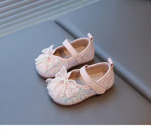 Vista detallada de zapatos de princesa rosa con lentejuelas y lazo de perlas para bebé