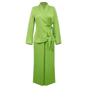 Close-up of lime green two-piece set featuring wrap blouse and wide-leg trousers.