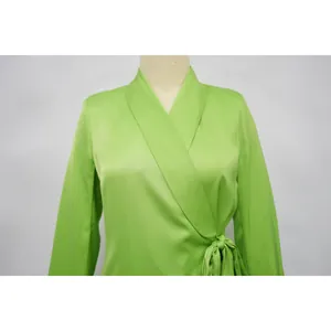 Close-up of bright green satin wrap top showing shawl collar and side waist tie.